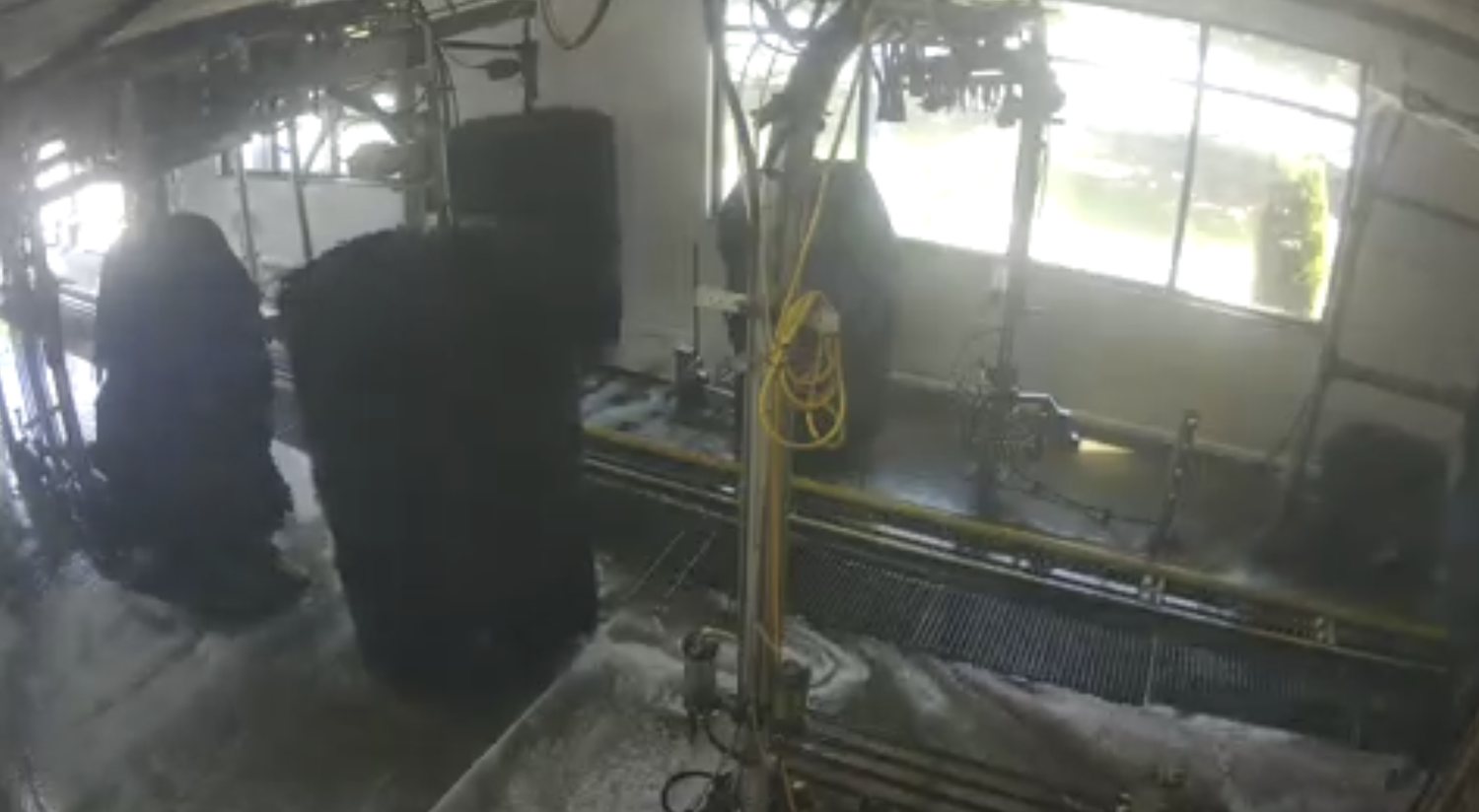Tunnel camera frame with bright windows behind equipment and a dark foreground wash area.